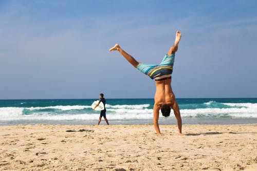 man on beach handstand